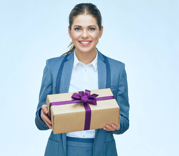 Young business woman standing with gift box against white backgr - Fotó, kép