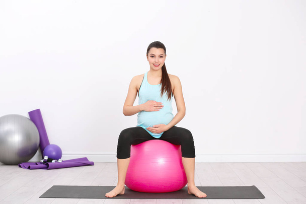 Young pregnant woman training in gym. Health concept - Valokuva, kuva