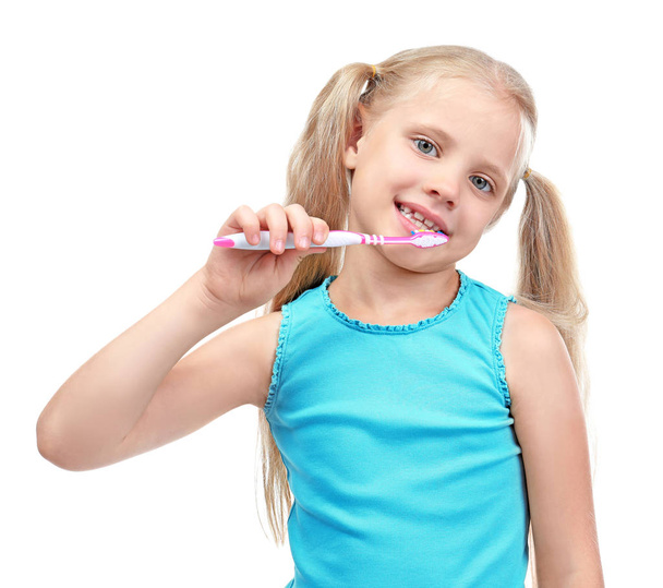 Cute little girl cleaning teeth on white background - 写真・画像