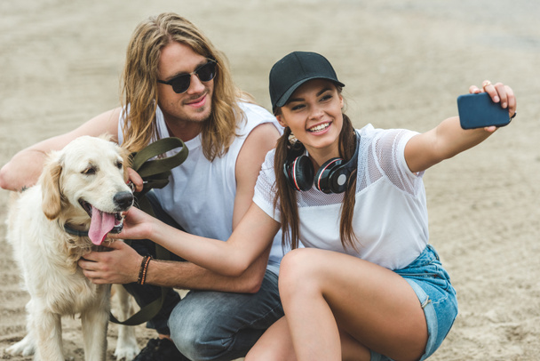 couple with dog taking selfie - Foto, immagini