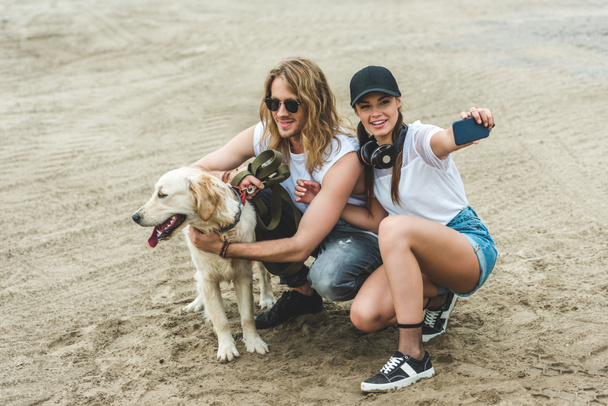 couple with dog taking selfie - Foto, imagen