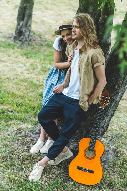 casal com guitarra no parque
 - Foto, Imagem