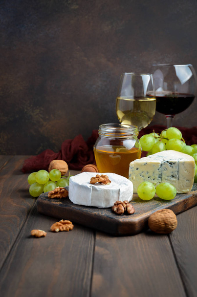 Különböző sajt, szőlő, dió, bor. - Fotó, kép