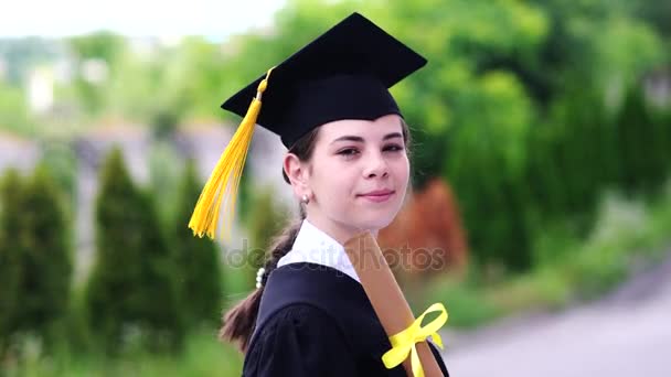 Εξωτερική σκηνή της όμορφης φοιτήτριας αποφοίτηση ντυμένος στο κύπελλο και φόρεμα. - Πλάνα, βίντεο
