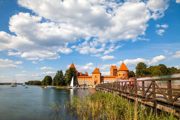 Los turistas visitan el castillo de Trakai en un soleado día de verano, buen momento para hacer un viaje en barco. Larga exposición, desenfoque de movimiento
 - Foto, imagen