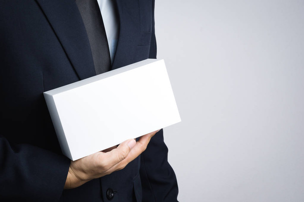 Uomo d'affari mano in possesso di scatola bianca vuota dare regalo
 - Foto, immagini