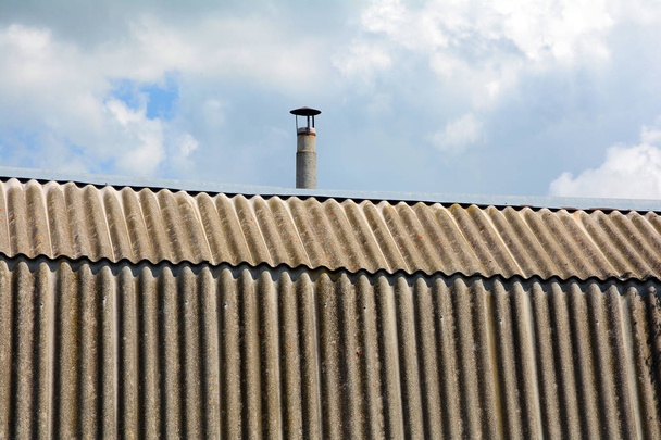 Stary dach łupki azbestu dach i komin przeciw błękitne niebo - Zdjęcie, obraz
