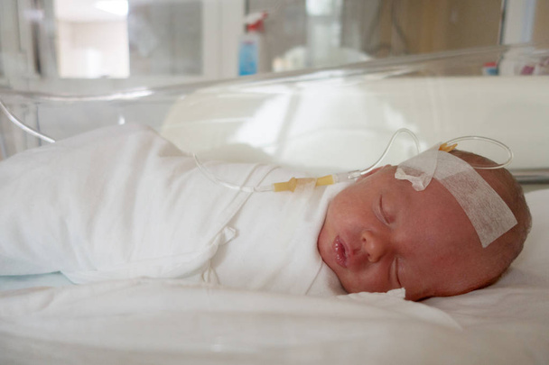 Newborn baby sleeping on a drip in a hospital - Φωτογραφία, εικόνα
