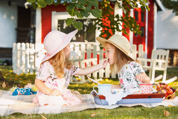 Two little girls sitting on green grass - Фото, зображення