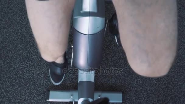 Young attractive man cycling on the exercise bike in the gym - Filmagem, Vídeo