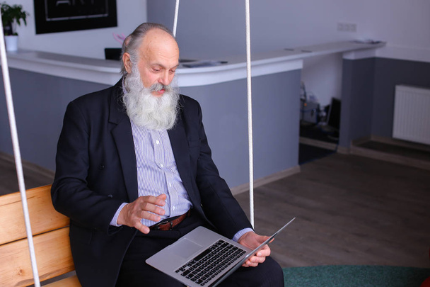 Vieil homme à la retraite imprime sur ordinateur portable et parle avec ses collègues behin
 - Photo, image
