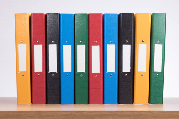 Row of coloured office document folders on shelf - Photo, Image