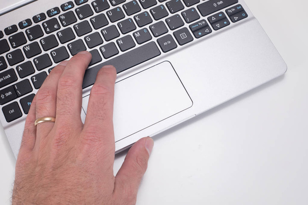 Рука людини з обручкою за допомогою клавіатури ноутбука
 - Фото, зображення