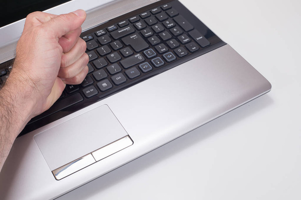Frustrated persons hand hitting laptop keyboard - Fotó, kép