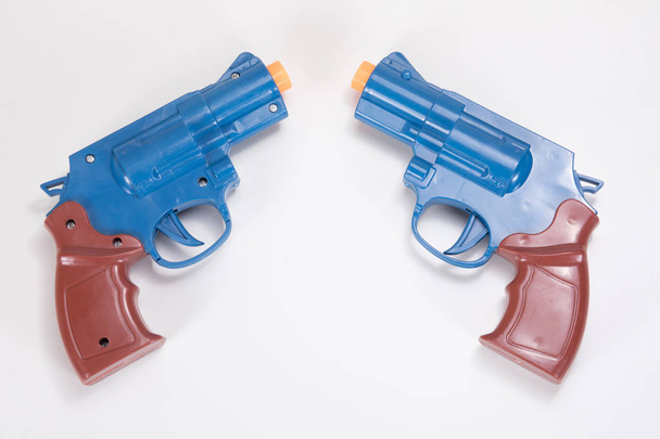 Twee plastic speelgoed pistolen met wit kopiëren ruimte - Foto, afbeelding