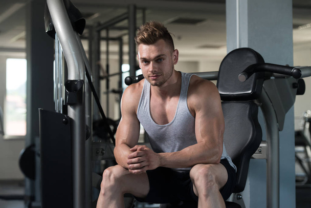 Man Resting On Bench In Fitness Center - Foto, afbeelding