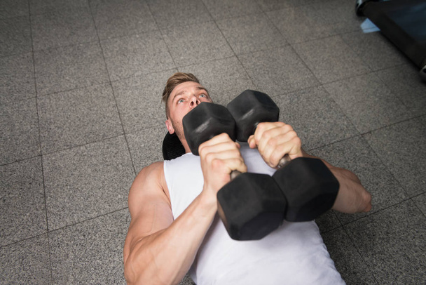 Bodybuilder Exercising Chest With Dumbbells In Gym - Foto, imagen