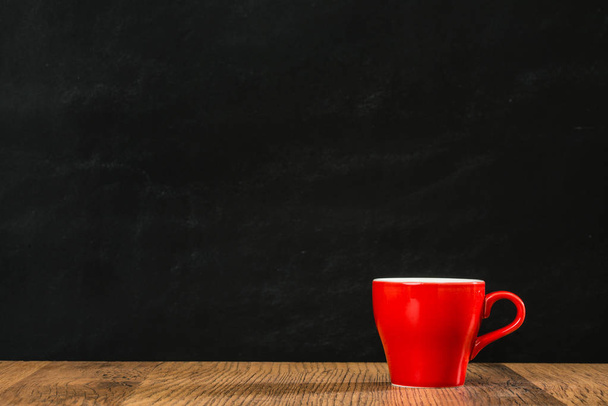 lonely red coffee cup with black wall background  - Foto, afbeelding