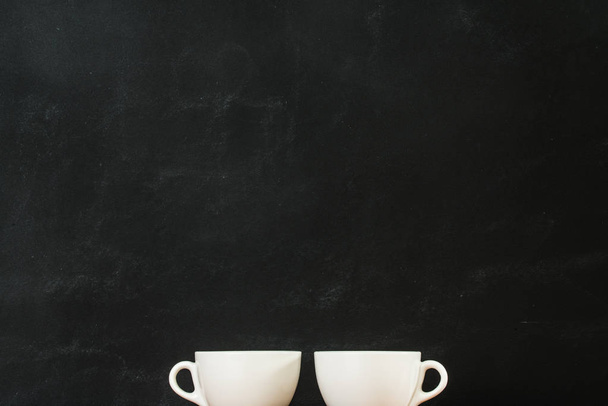 coffee cups showing at the bottom of the black - Φωτογραφία, εικόνα