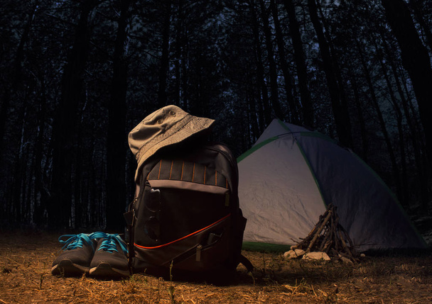 Bosque nocturno con equipo de mochila y ropa
. - Foto, imagen