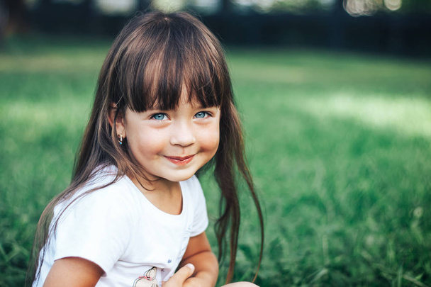 Красивая маленькая девочка смотрит в камеру и улыбается
 - Фото, изображение