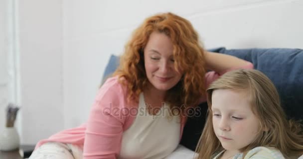 Mother And Daughter Using Laptop Computer While Father With Son Touch Digital Tablet Happy Smiling, Family Sitting On Bed Spend Time Together At Home - Footage, Video