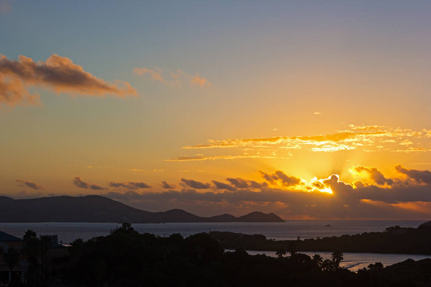 Sun about to appear above the clouds at sunset on St Thomas Island, US VI.  - Foto, immagini
