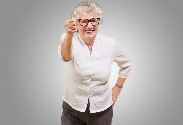 ritratto di adorabile donna anziana che fa un buon gesto sul grigio
 - Foto, immagini