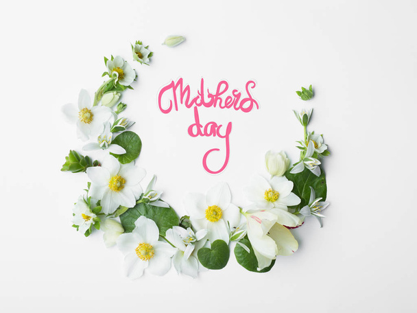 Concept mother's day, beautiful flowers lined on white with insc - Фото, зображення