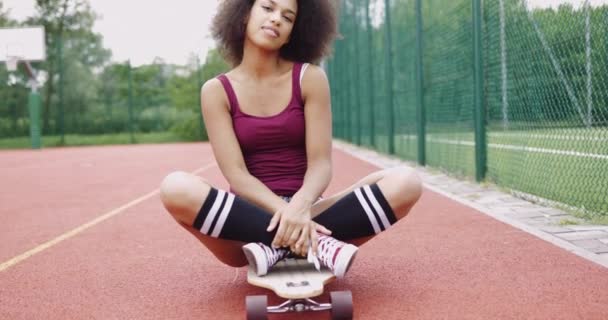 Charmantes Modell sitzt auf Skateboard - Filmmaterial, Video