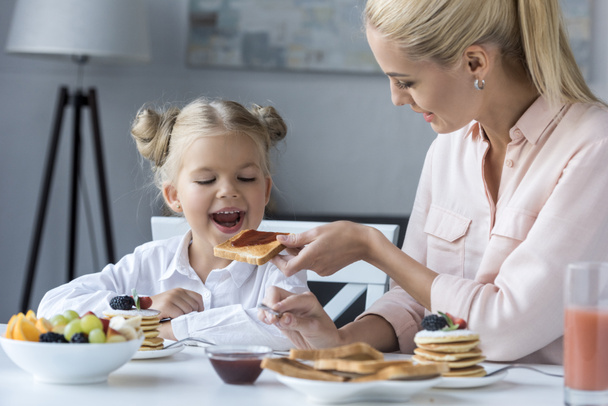 mother and daughter having breakfast - Photo, image