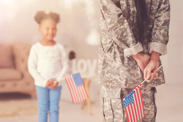 Female in military uniform holding American flag - Фото, изображение