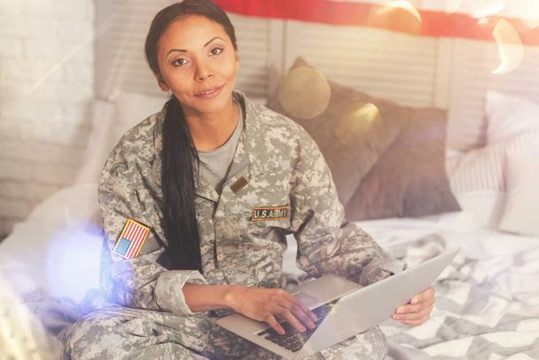 Militaire vrouw poseren met een laptop in bed - Foto, afbeelding