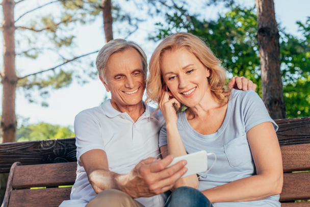 senior couple using smartphone together - Фото, зображення