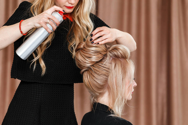 Vue rapprochée d'un coiffeur coiffeur fait coiffure du soir au modèle blond dans le salon
 - Photo, image