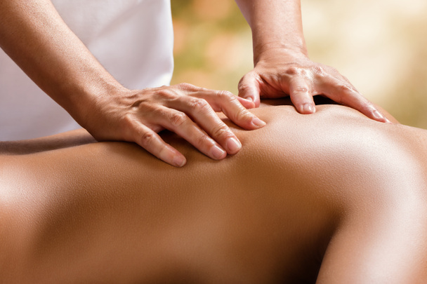 therapist hands on female back. - Foto, afbeelding