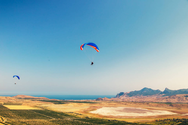 Paragliders fly over the valley. - Φωτογραφία, εικόνα