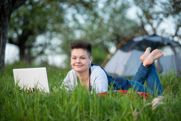 mujer usando su portátil mientras acampa
  - Foto, imagen