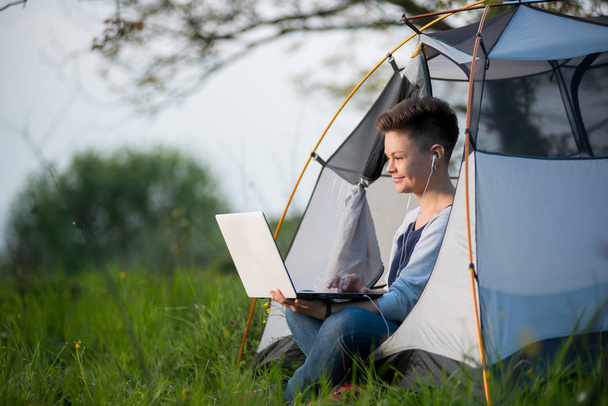 kobieta siedzi w namiocie przy użyciu jej laptop  - Zdjęcie, obraz
