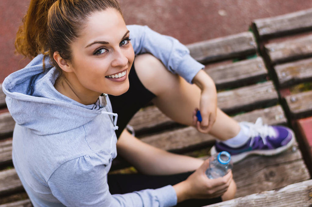 fit woman sitting on bench - Photo, Image