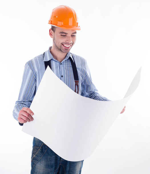 Male architect looking at blueprints against white background - Foto, imagen