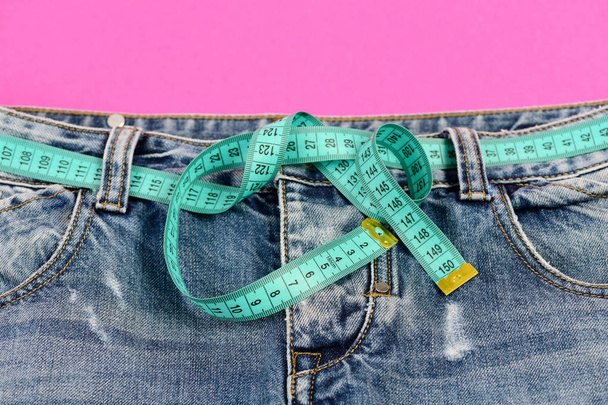 Top part of denim trousers on pink as dieting concept - Photo, Image