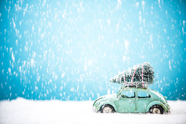 Старовинний автомобіль з сосновим деревом на даху в снігопаді
 - Фото, зображення