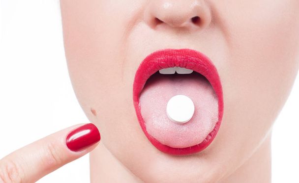 Open mouth holding medicine pill on tongue.  - 写真・画像