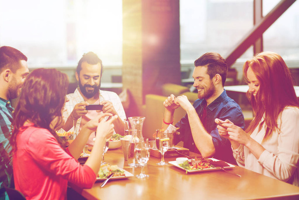 happy friends taking picture of food at restaurant - Foto, Bild