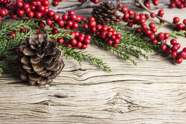 Décoration de Noël de cône de pin et d'hivernage rouge sur vieux bois
 - Photo, image