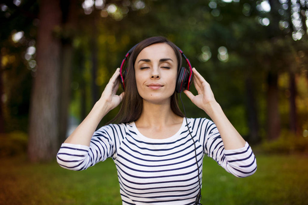 woman with headphones enjoying music outdoors - 写真・画像