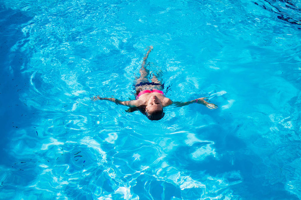 Mujer en la parte de atrás en la piscina, vista superior
 - Foto, Imagen