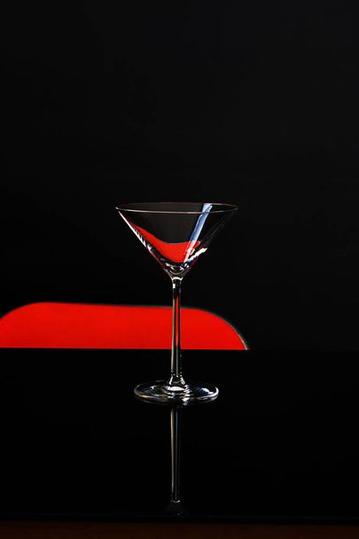 An isolated glass for martini on dark and red background - Photo, Image