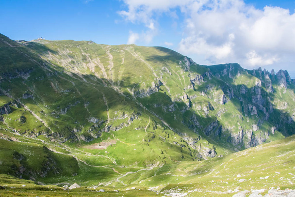 Vista panorámica sobre las montañas de Carpatian, los valles verdes y el cielo azul hermoso en el fondo, parque natural de Bucegi, Rumania, en día soleado del verano
. - Foto, imagen